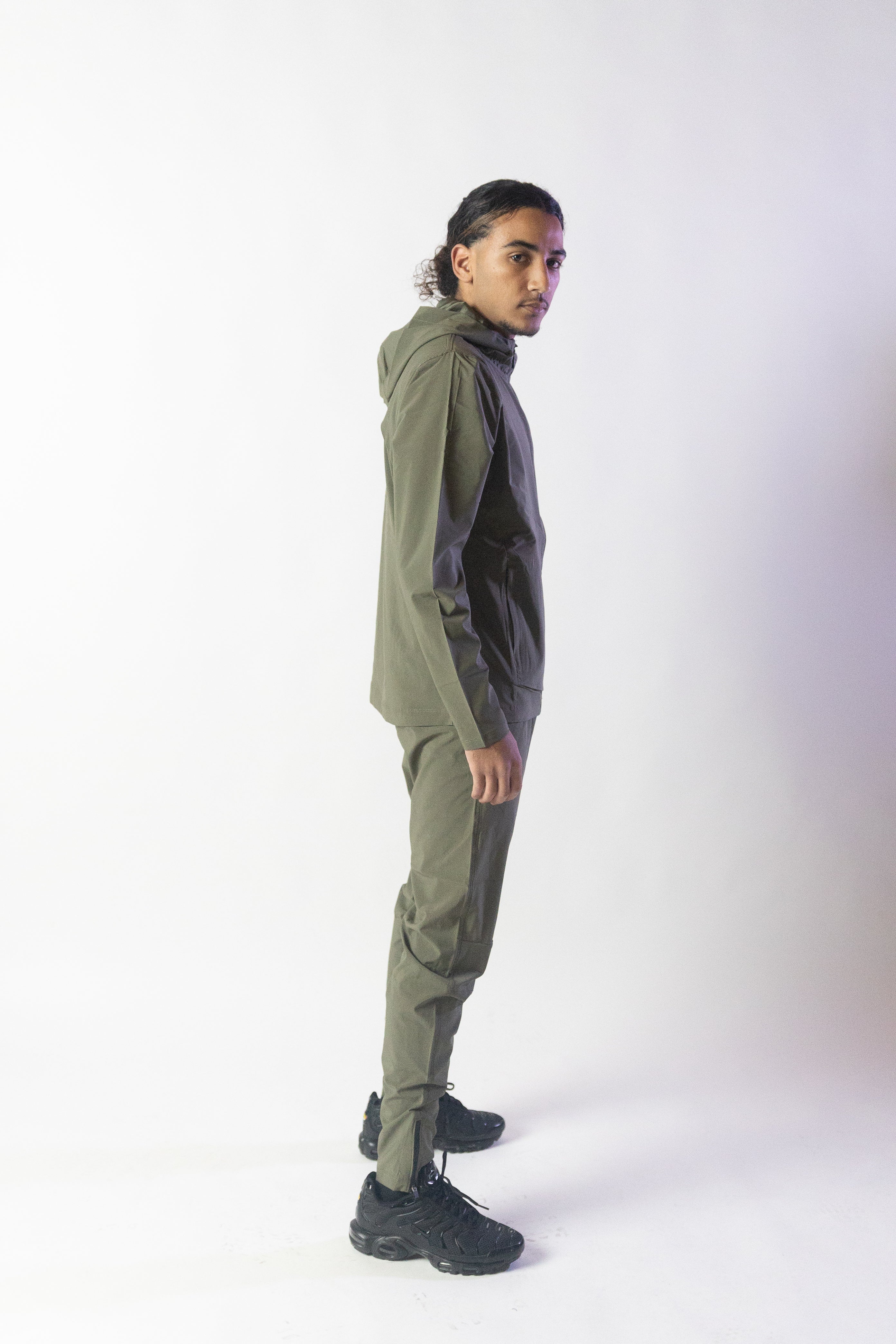 Image du survêtement Stockholm de Mauritti en kaki, un ensemble zippé à capuche combinant style décontracté et confort sportswear. Ce modèle, fabriqué en polyester et élasthanne, offre une grande souplesse et un toucher agréable. Il est équipé de poches pratiques, d'une capuche ajustable, d'une fermeture éclair sur le devant, ainsi que de zips aux chevilles pour une finition moderne et fonctionnelle.